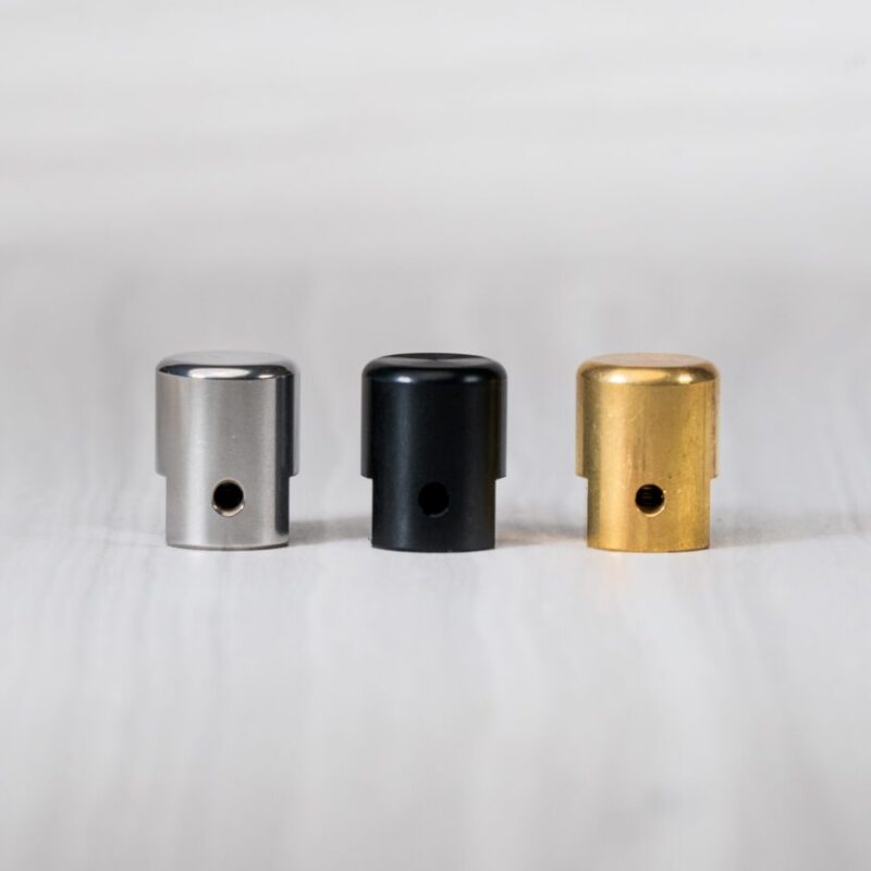 Three metallic spray paint caps in row.