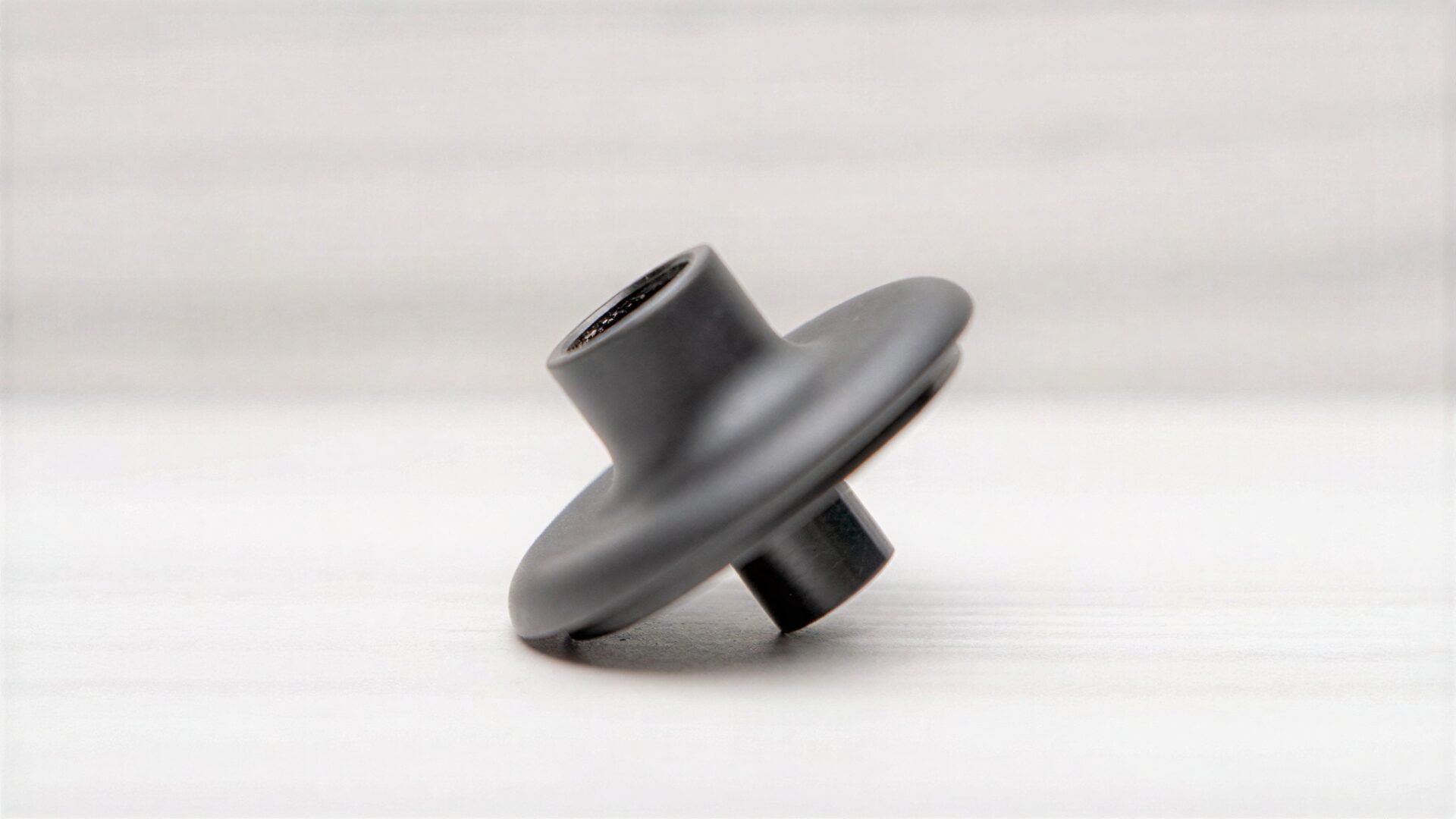 Black industrial metal component on white background.