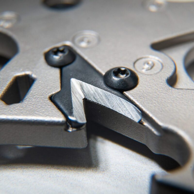 Close-up of metallic mechanical component, screws visible.