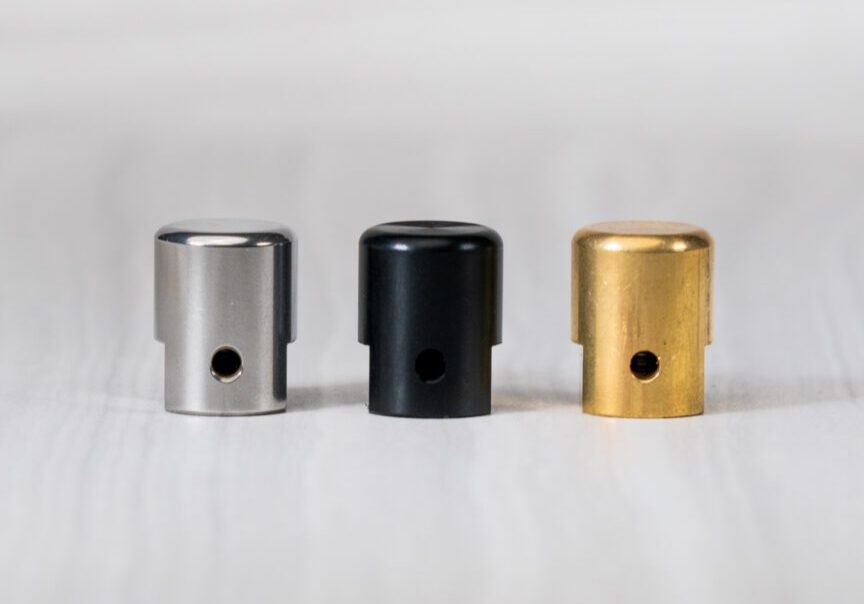 Three metallic spray paint caps in row.