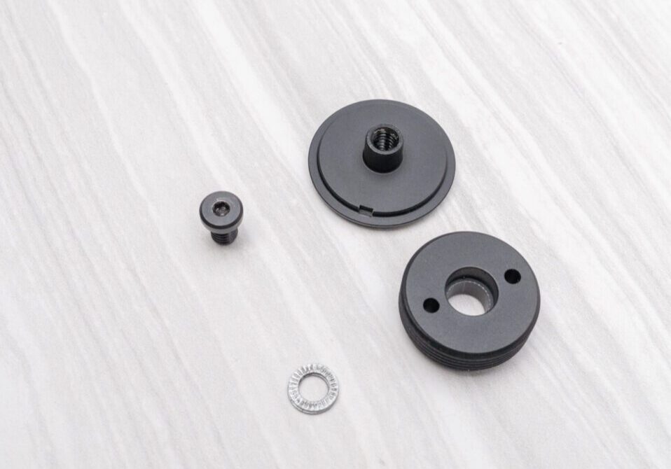 Black mechanical parts on a white surface.