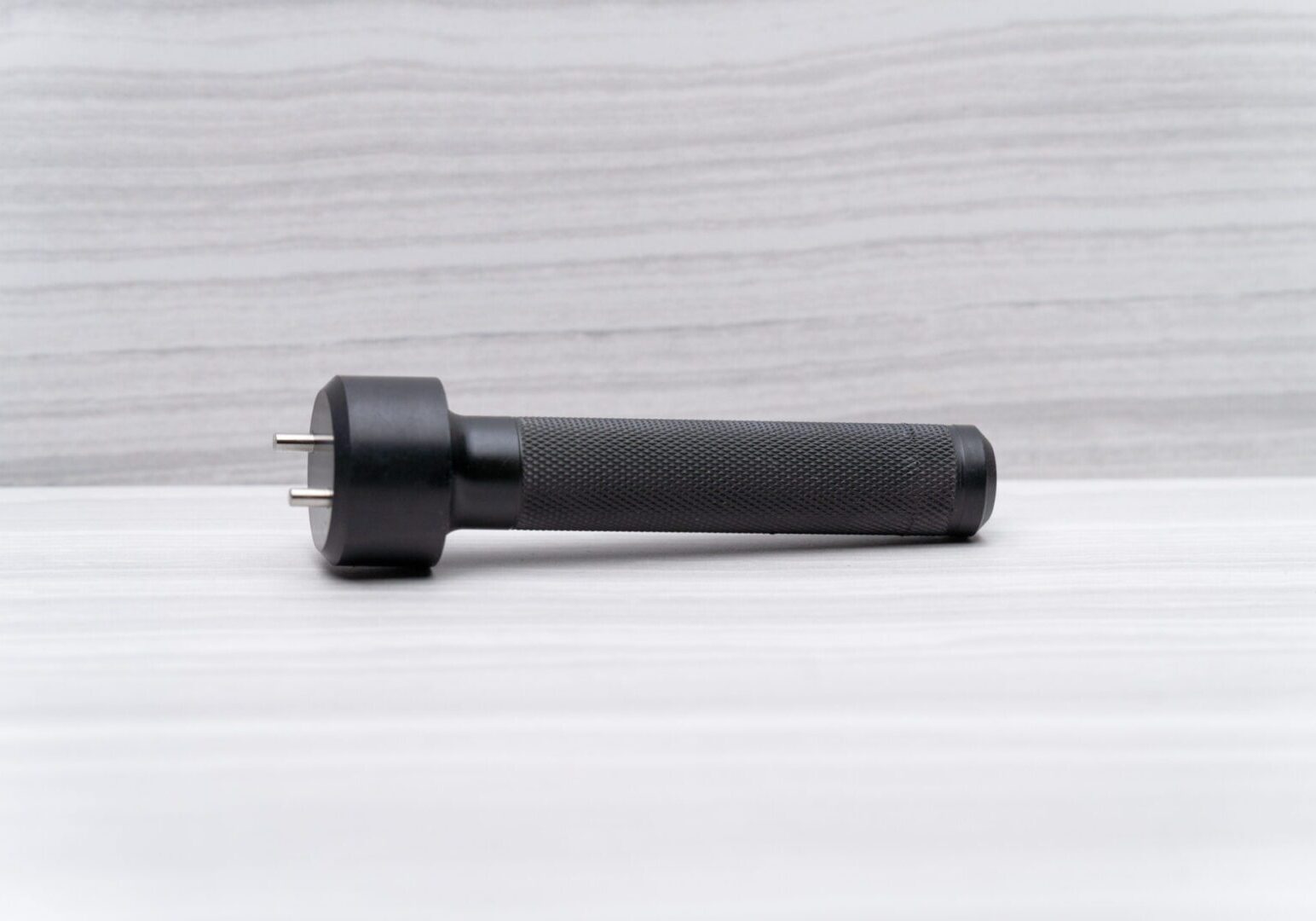 Black handheld device on a light surface.