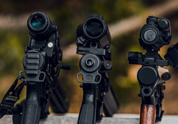 Rifles and ammunition displayed on a table.